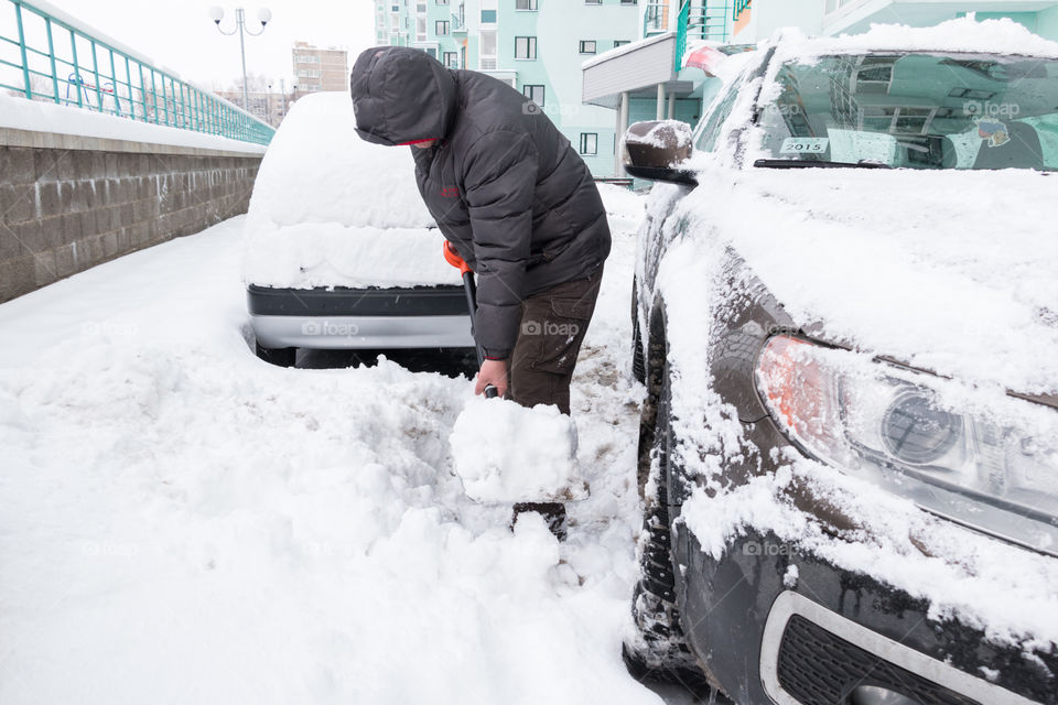 man removes snow with a shovel