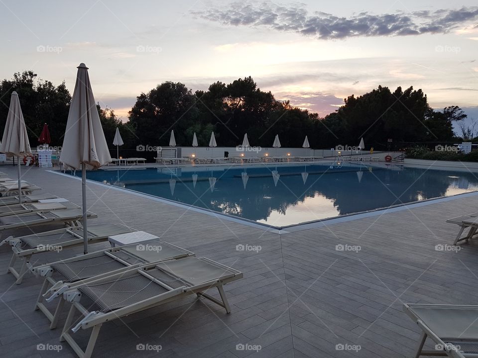 Empty swimming pool at sunset