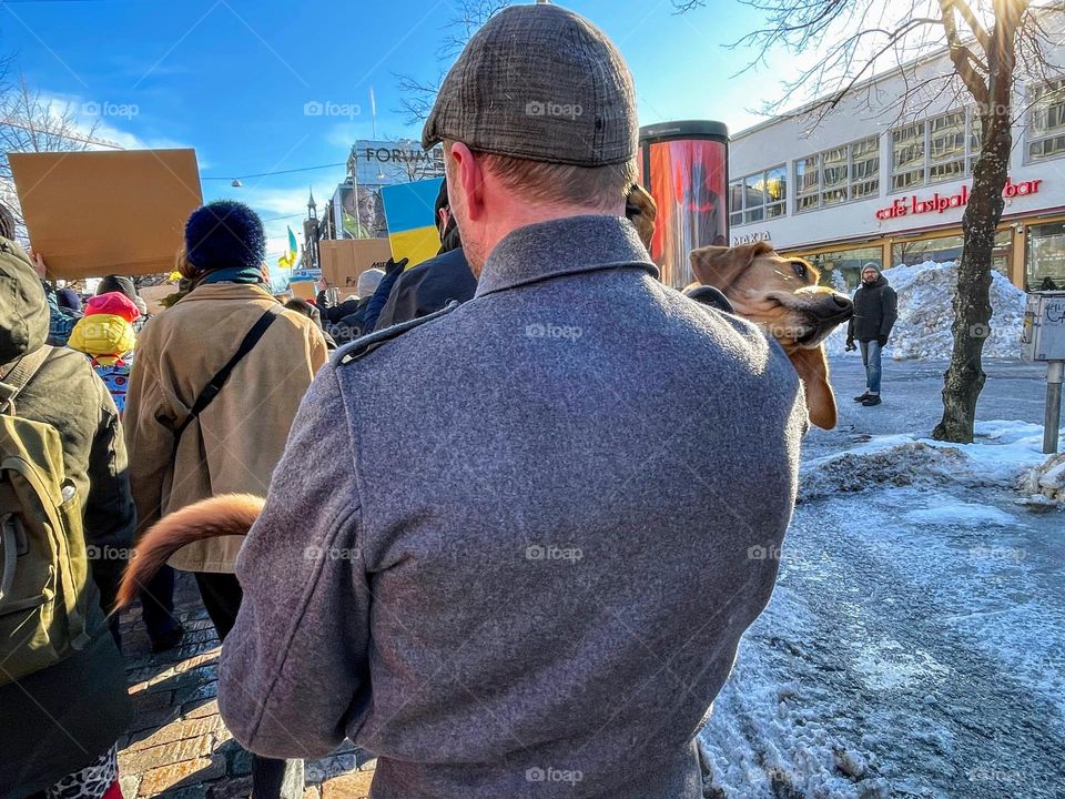 Men carries his dog on the demonstration against war in Ukraine