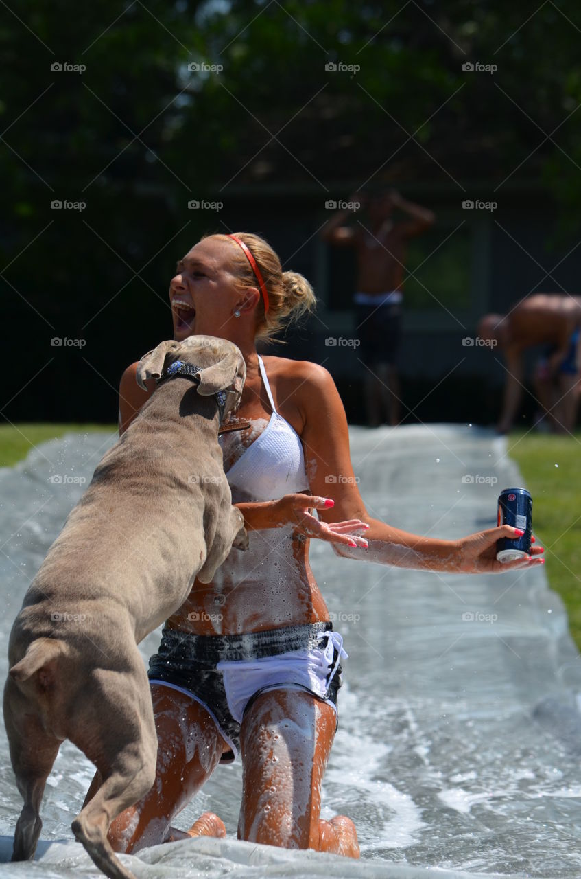 Happy woman holding beer can with dog