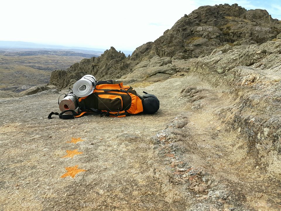 Backpack of climber next to signs in the mountain