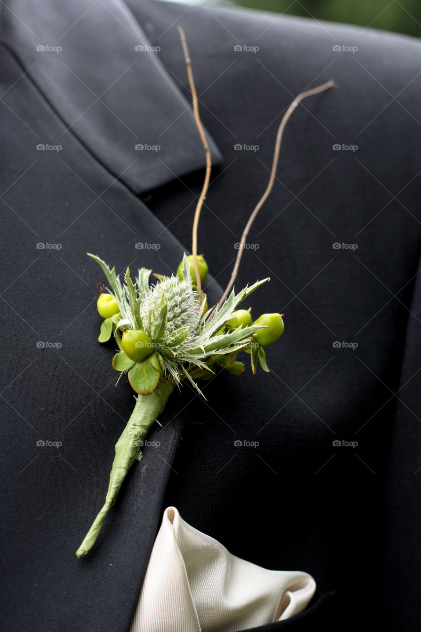A grooms boutonniere  on the lapel of his suit