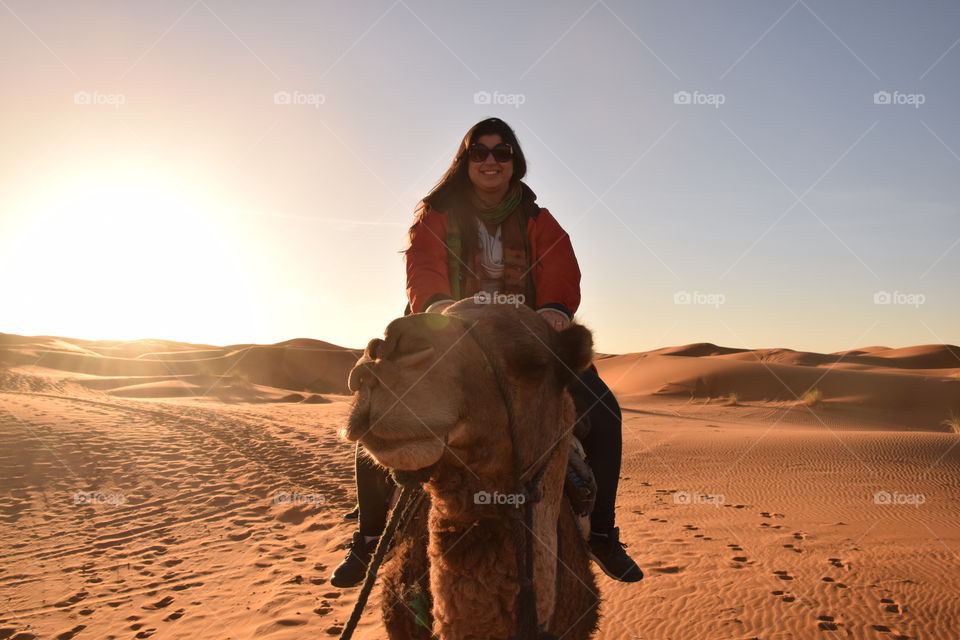 Woman riding dromedary, at Sahara desert, Morroco
