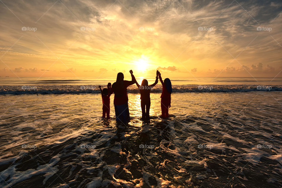 A happy family enjoyed beautiful sunset on the beach