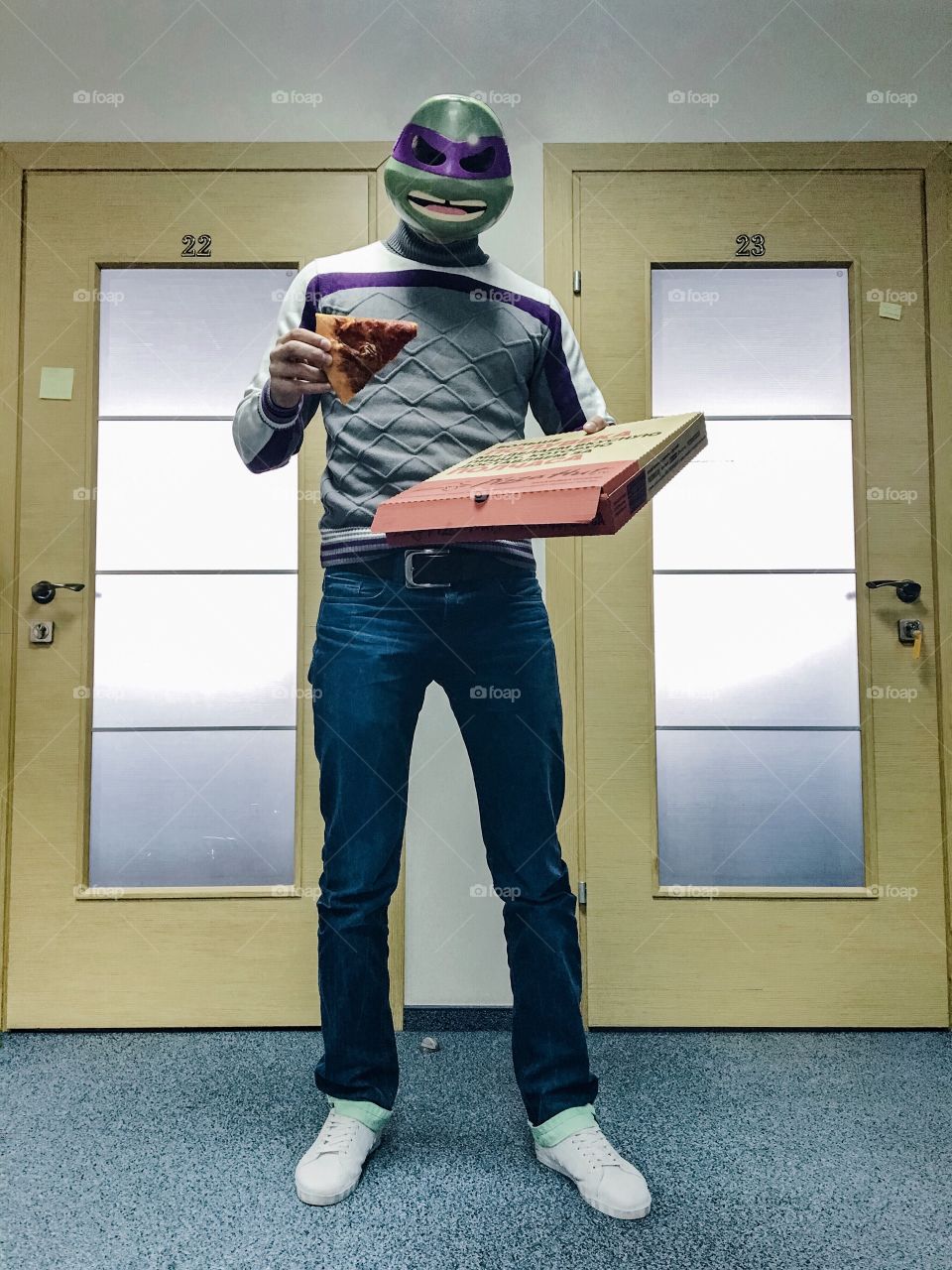 Man in mask of ninja turtle from TMNT with pizza box in office