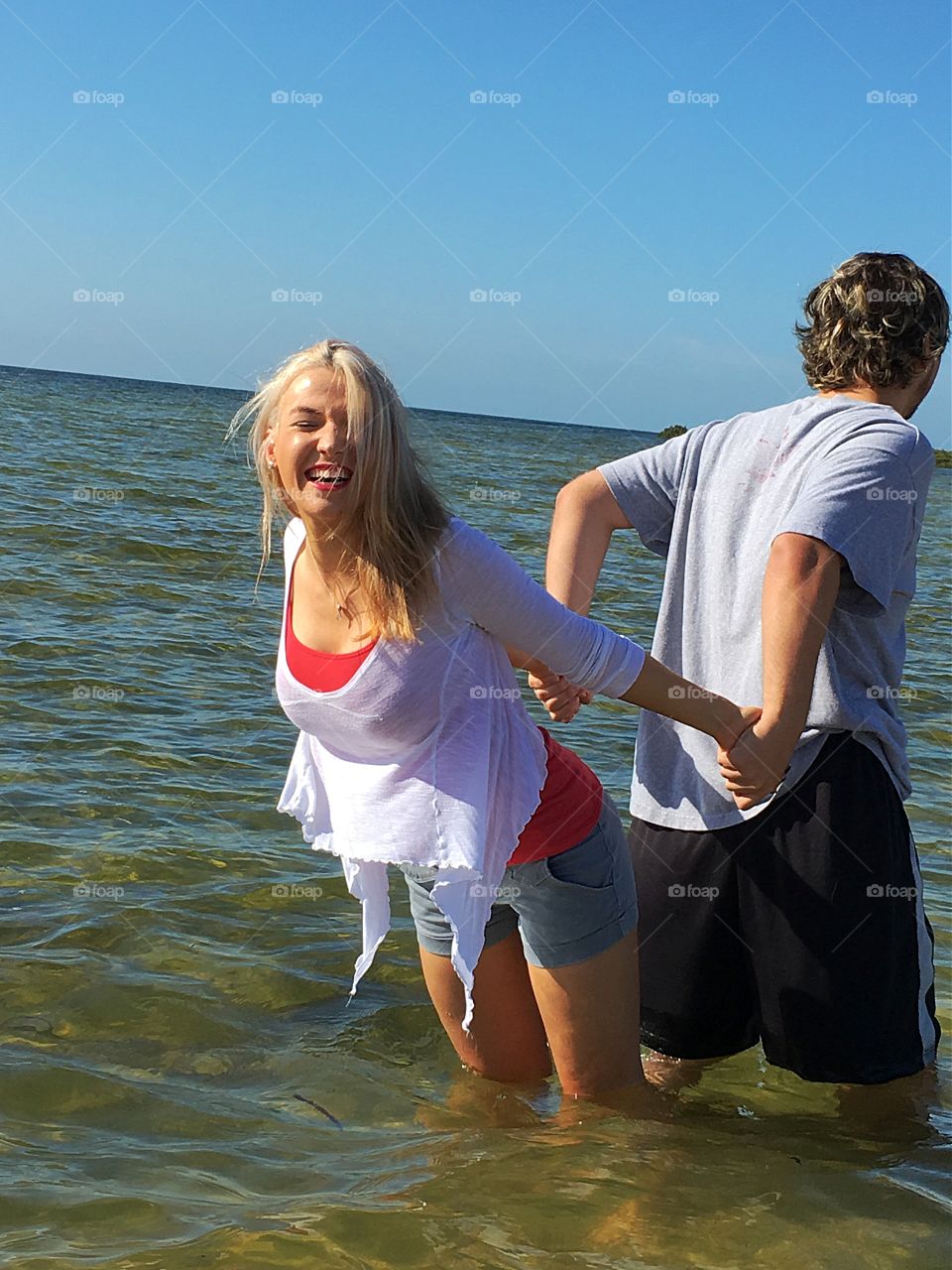 Couple posing back to back in sea