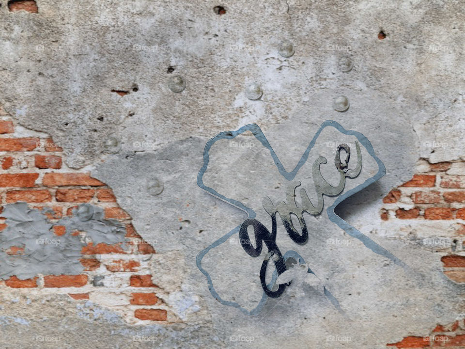 Urban grace image of a cross with the word grace on a cement and brick background.