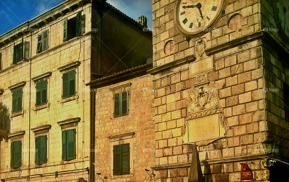 old buildings with green windows and clock