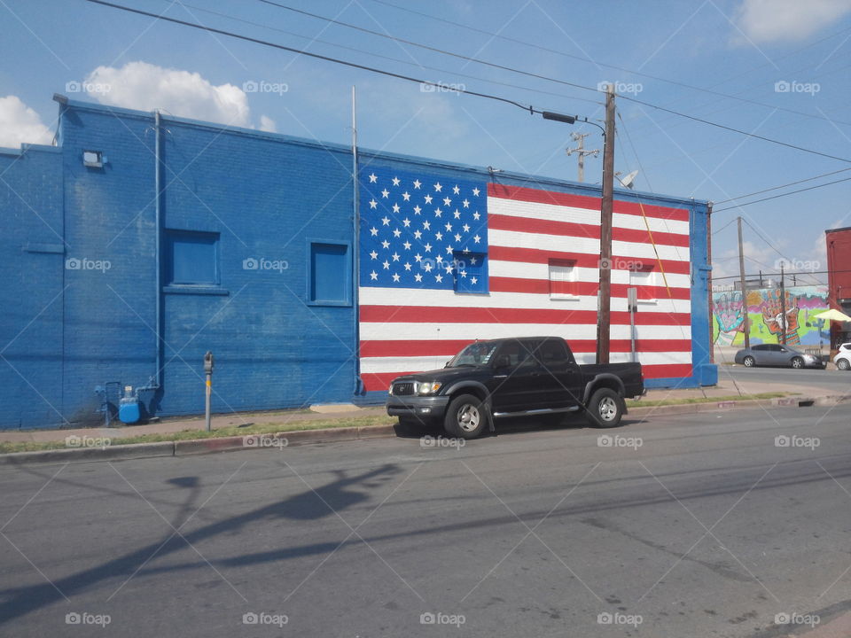 An American flag mural with a truck in front.