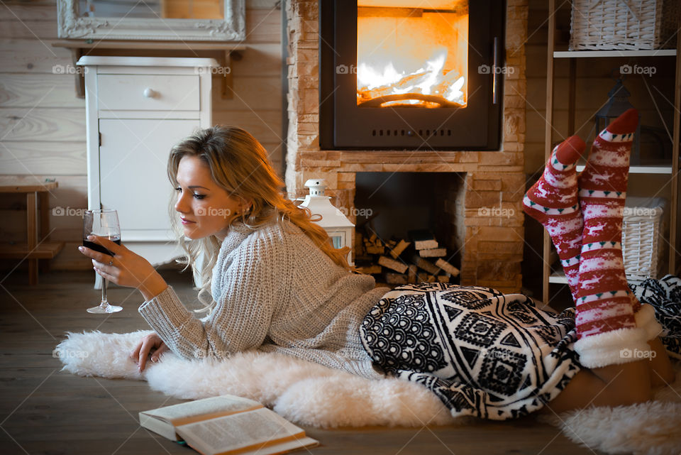 Beautifyl woman holding wine glass  in cozy mountain cabin