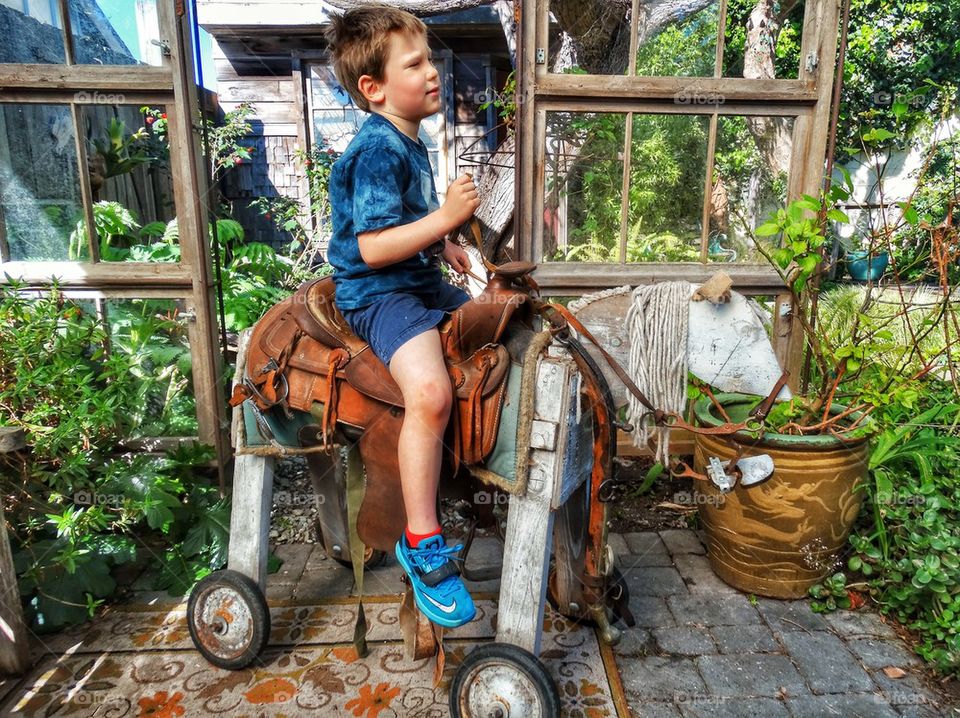 Boy Riding A Toy Horse