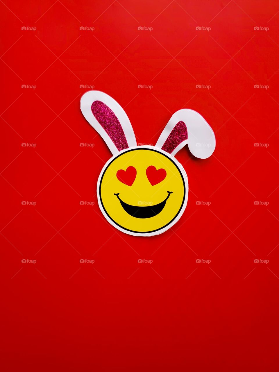 A modern relatable take on The traditional Year of the Rabbit!- A rabbit ear Emoji with heart eyes on a  red background!