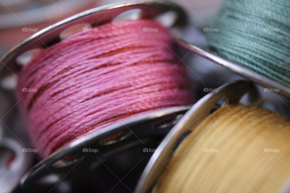 Pink, yellow, teal thread on bobbins