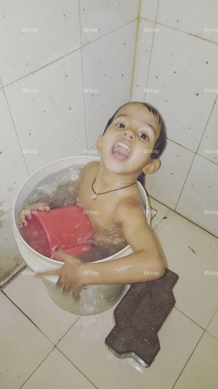This baby is taking a bucket, So Cute Baby, Beautiful baby, The baby is taking bath in the bathroom, This Girl in the bucket, Enjoy in Summer Time, Nice