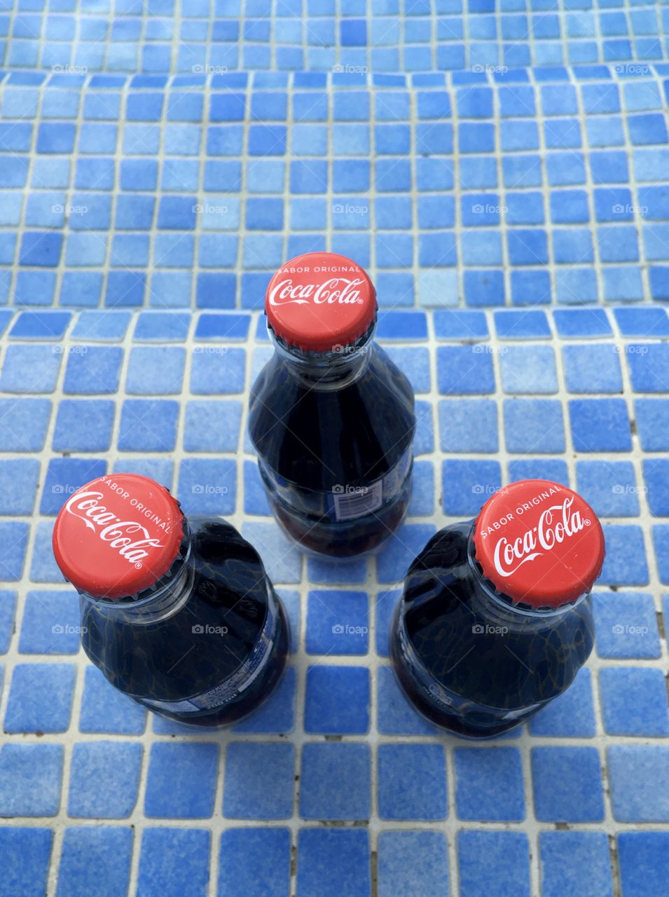 Fresh bottles of Coca-Cola in the swimming pool
