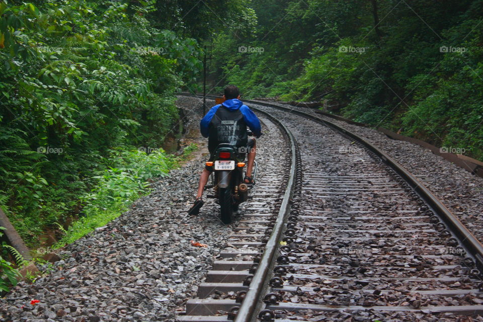 a two wheeler driving along the railway track