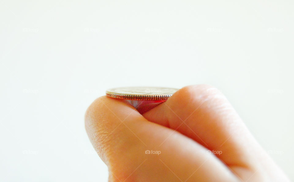 Can't decide, deciding, Toss coin, coin flip in hand, white background closeup