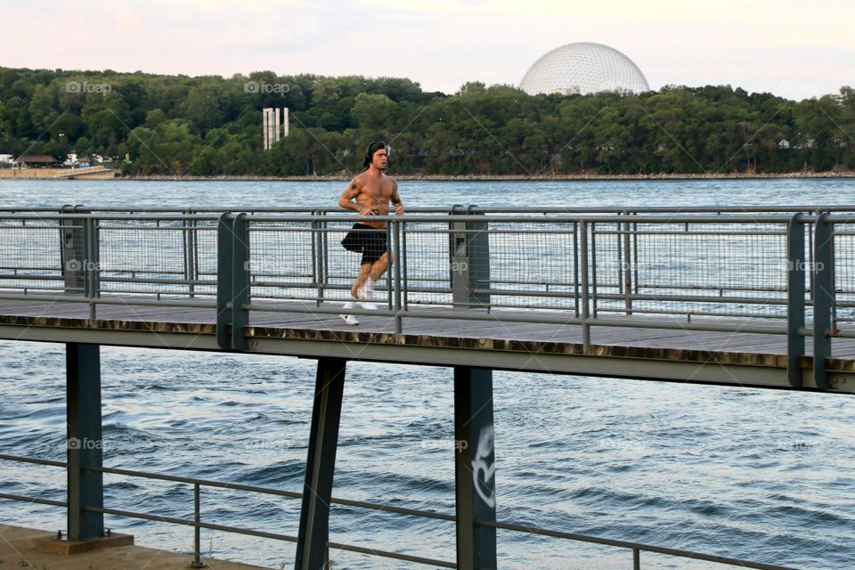 Young man running on bridge