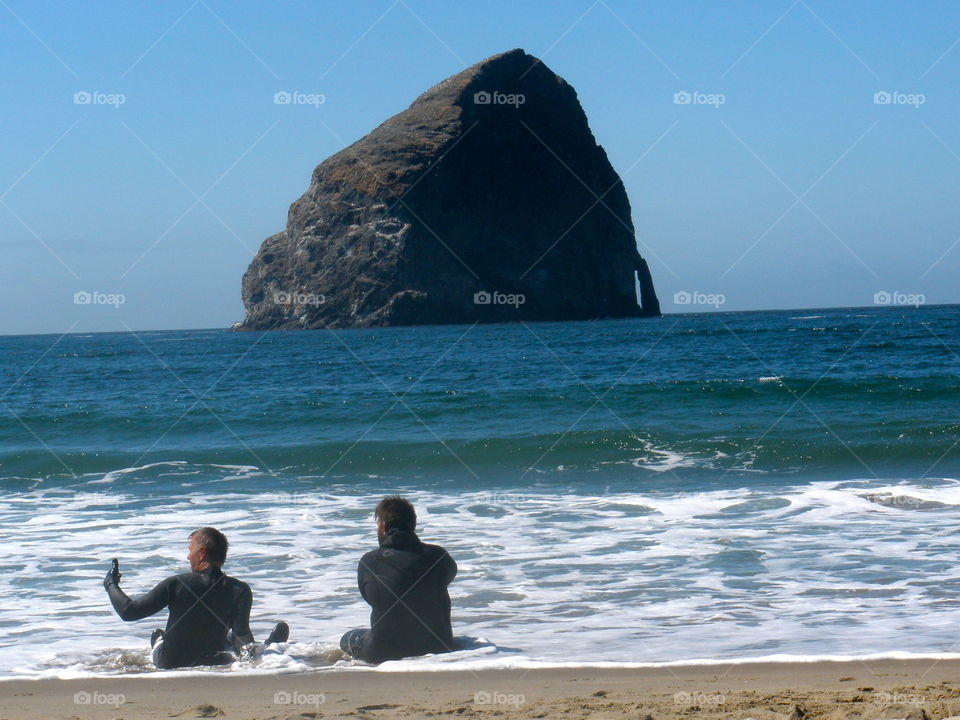 Surfers On Break. Two surfers sitting in water