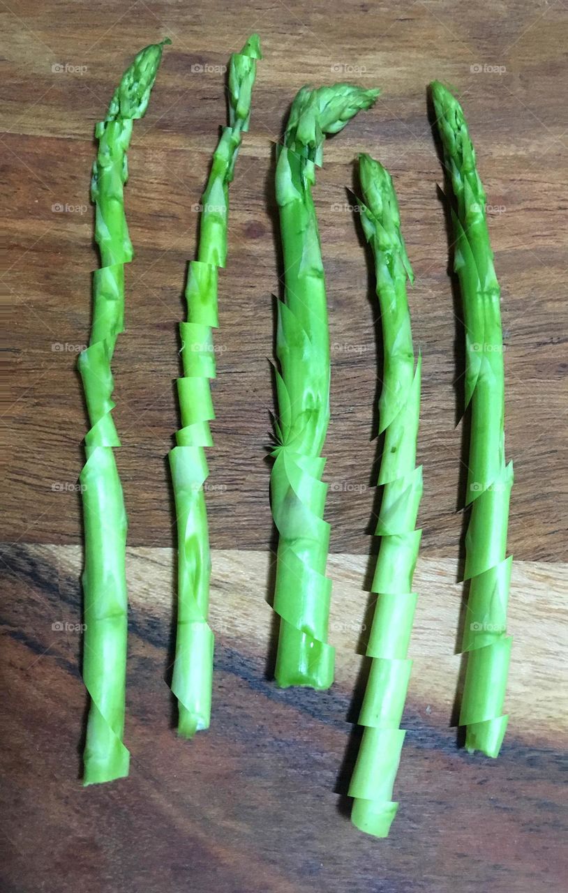 Sliced asparagus on a wooden cutting board 