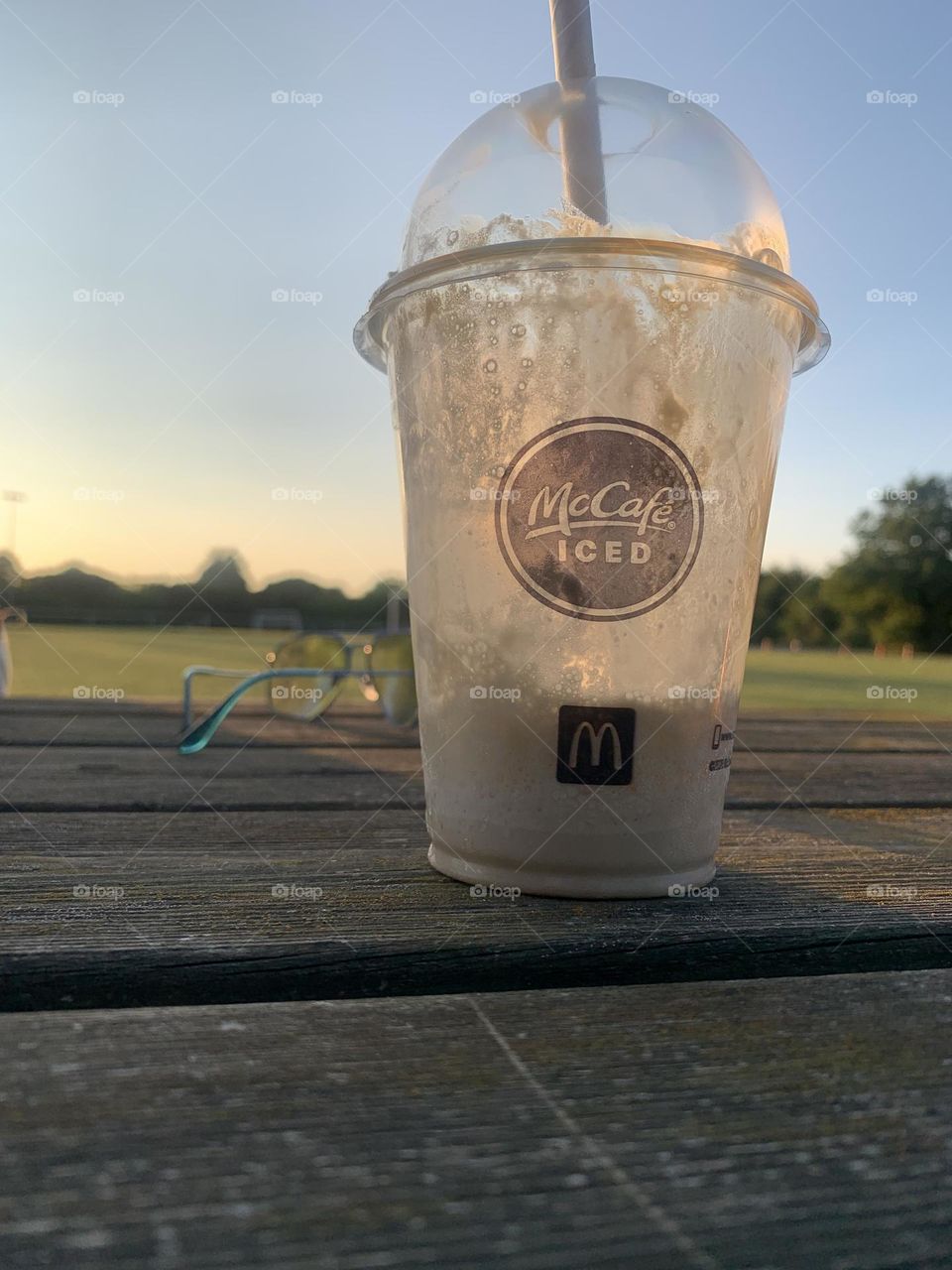 McDonald’s McCafe in front of open field view during sunset late summer 2024. Portrait taken on iPhone camera 