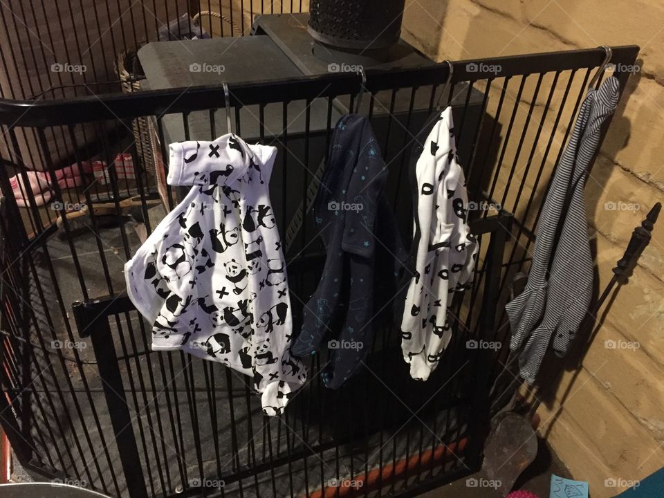 Baby clothes drying by the fire 