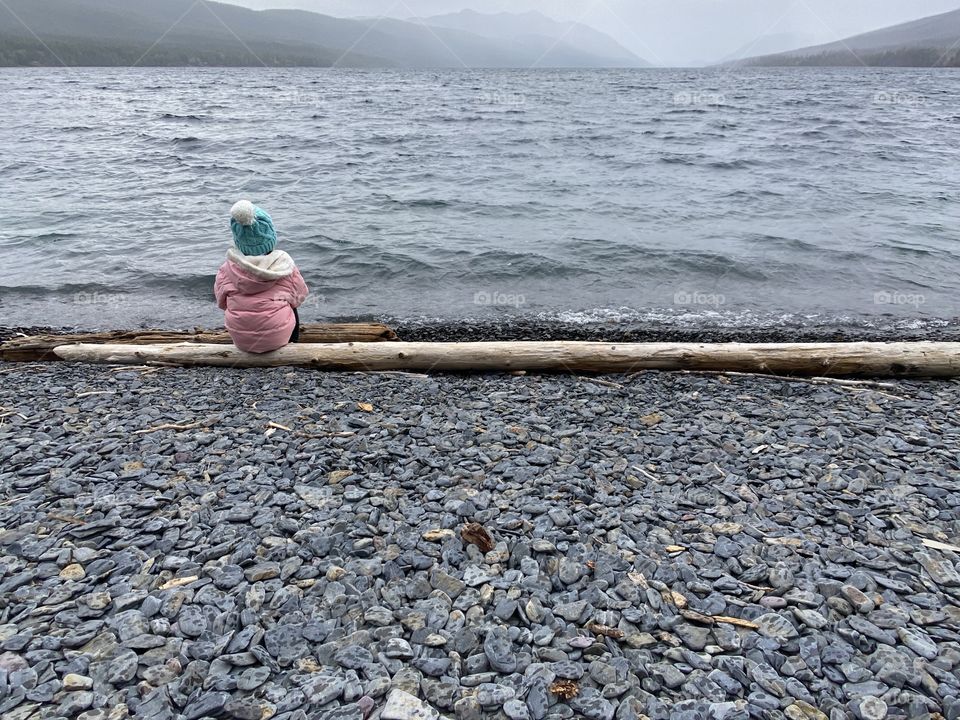 Girl in Pink Coat Watching Storm Come in on Lake McDonald in Glacier National Park, Montana