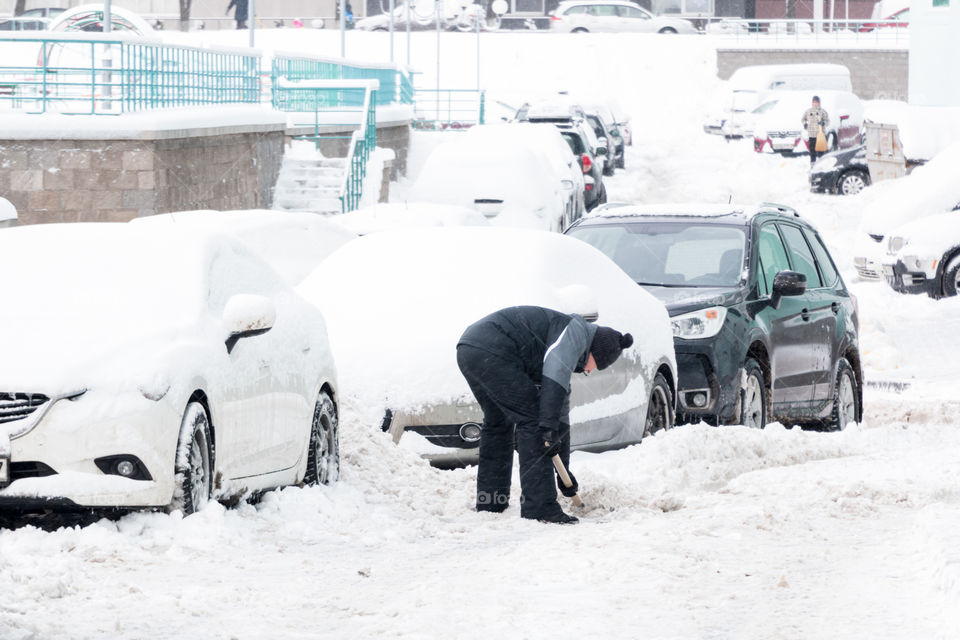 man removes snow with a shovel