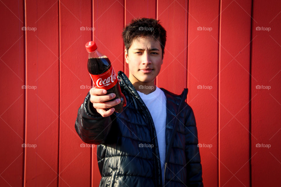 Young handsome man with a bottle of Coca-Cola