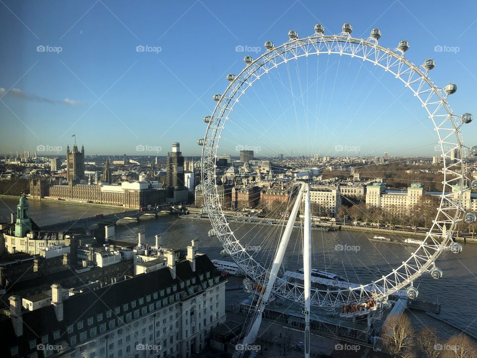 The London Eye against the city view and clear blue skies 