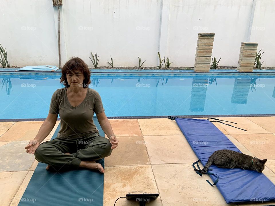 Woman and cat during on-line yoga lesson 