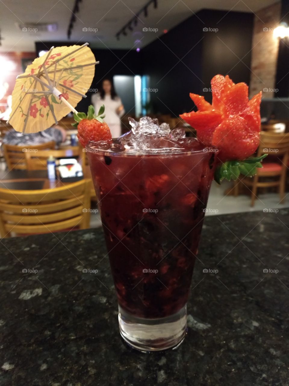 Cocktail de frutas vermelhas sem álcool com uma rosa feita de morango como decoração