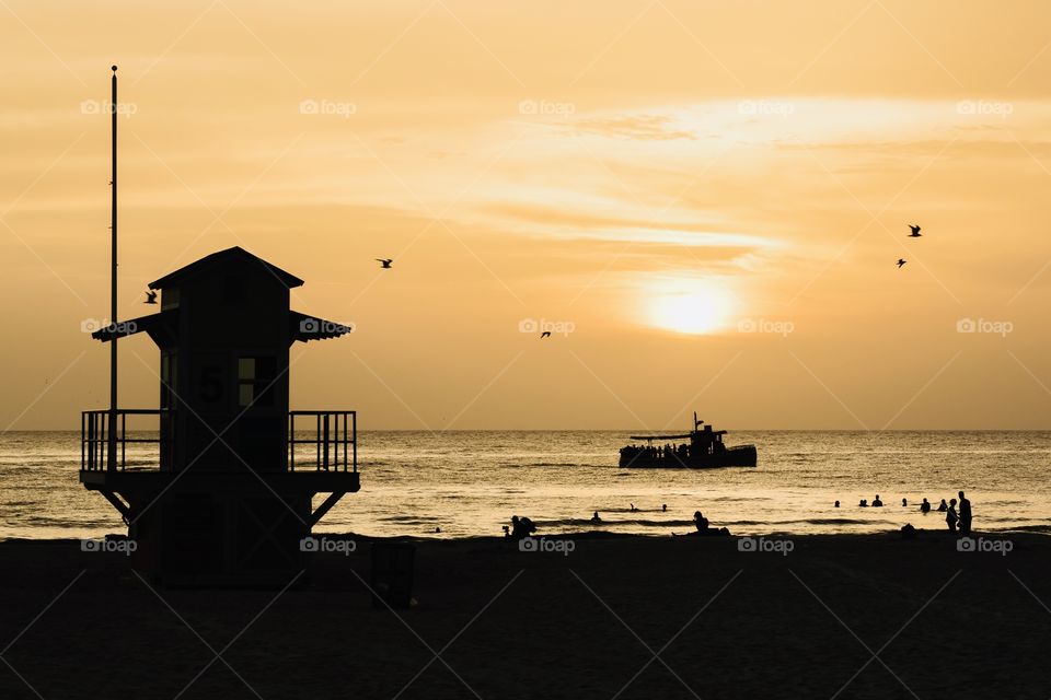 Silhouette of beach life and boat at sea 