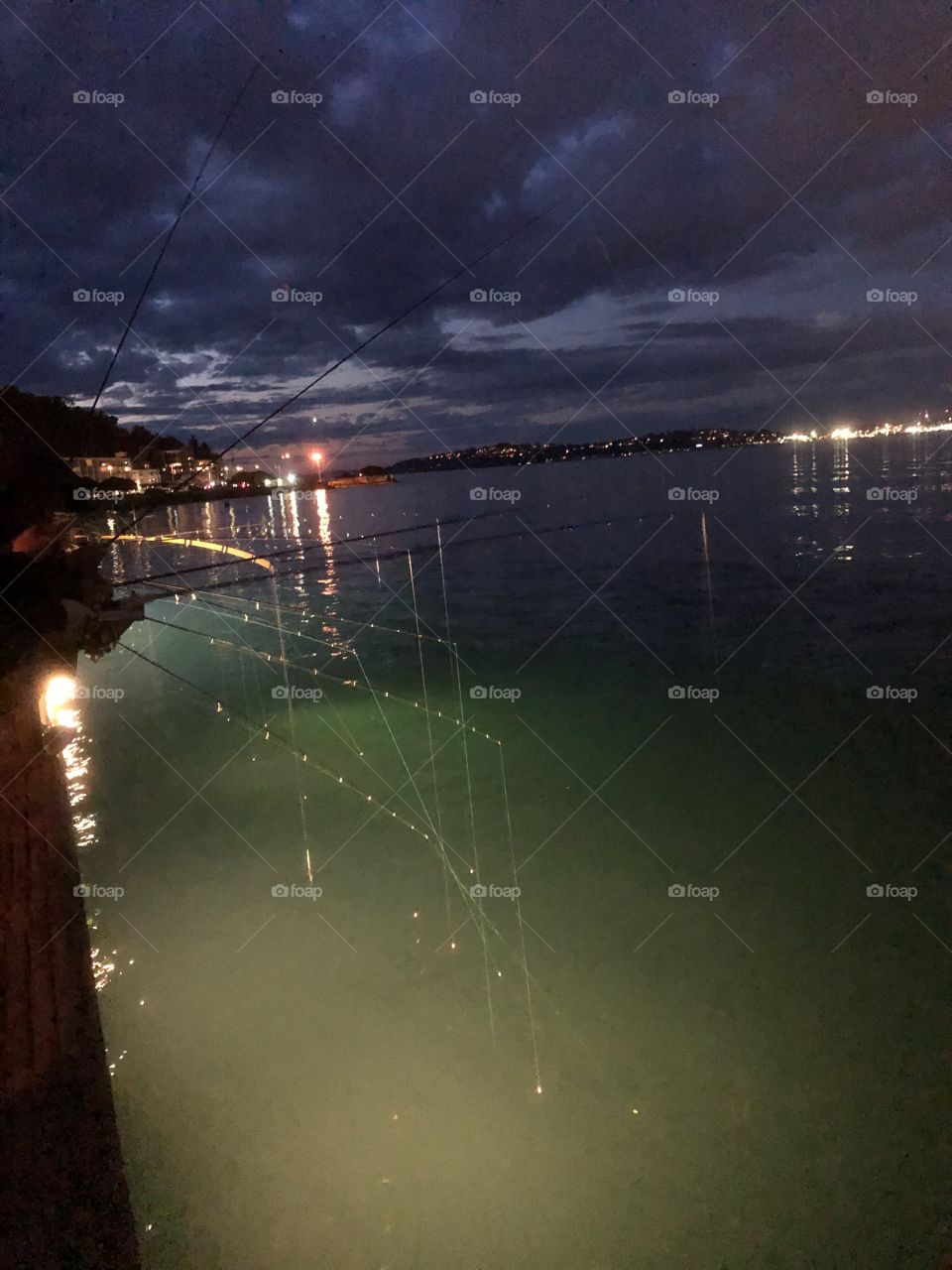 A number of amateur fishermen testing their luck with squids that can be fished out after sundown. The picture was taken near Alki Beach, Seattle