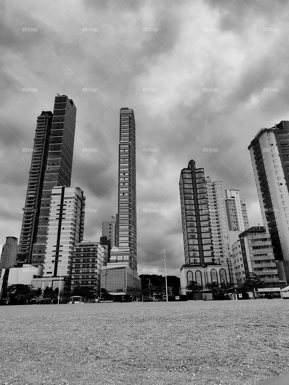 large buildings facing the sea.  Several vertical lines in front of the horizontal line.