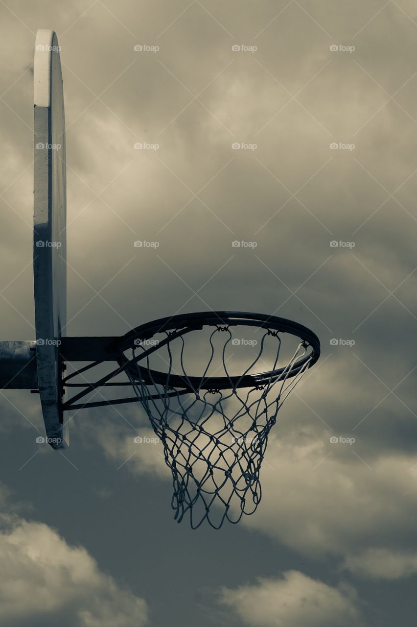 Basketball Hoop With Backboard With Clouds In Background, Basketball Net On Outdoor Court