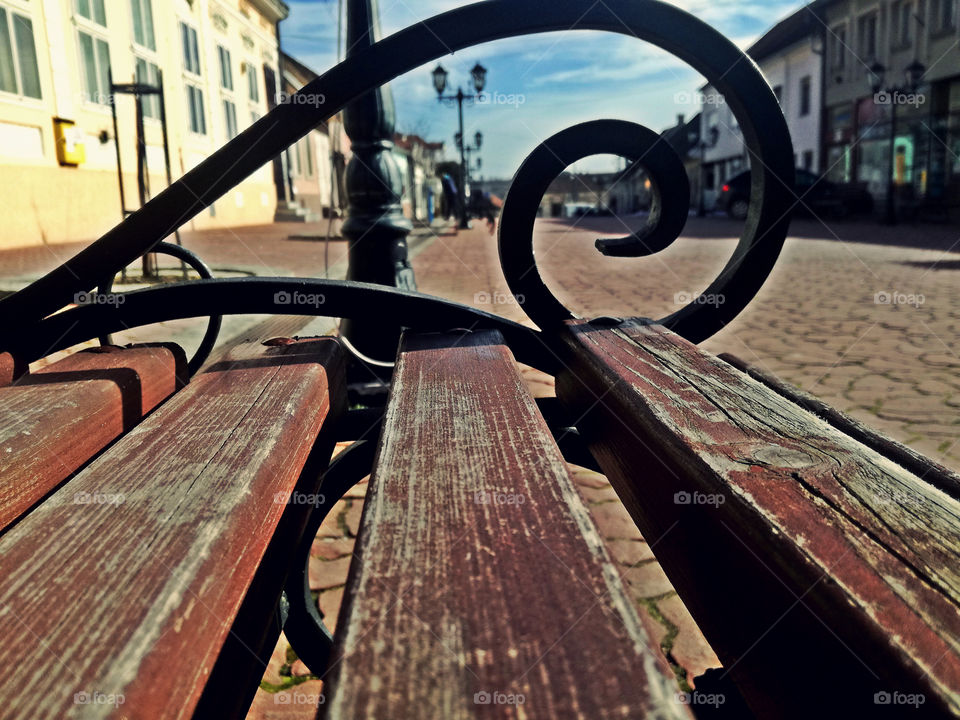 a wooden bench and a city in the background