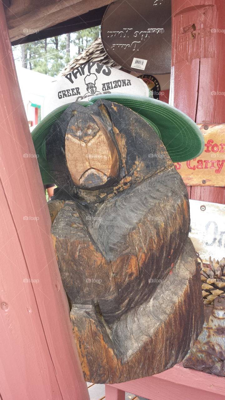 Wood carved bear with double billed hat