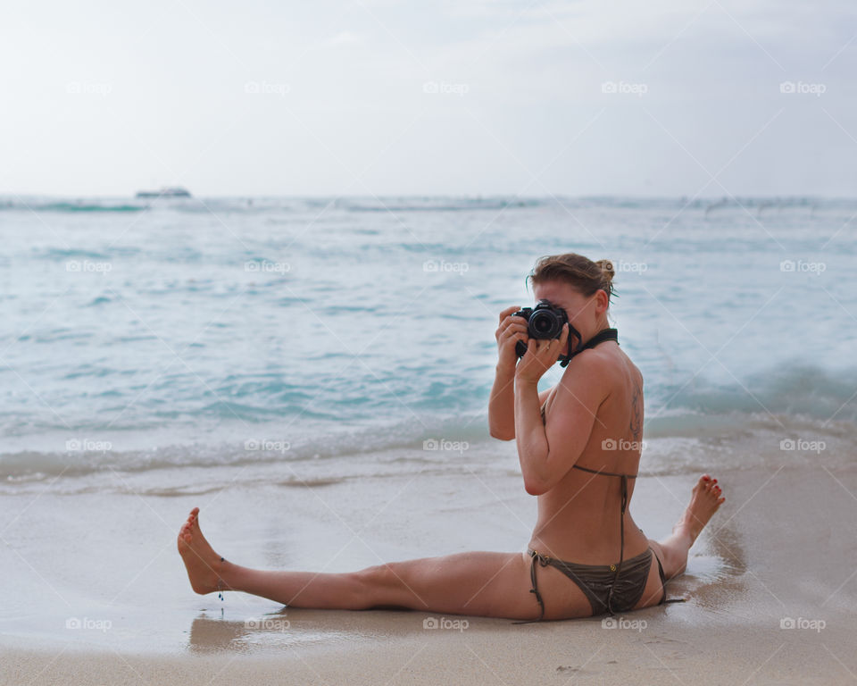 Beautiful photographer takes pictures on the beach in Hawaii 