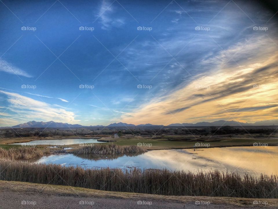 Dramatic clouds reflected in golf course lake