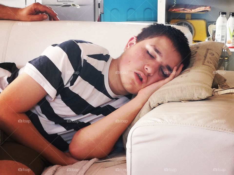 Teenager having an afternoon nap on sofa