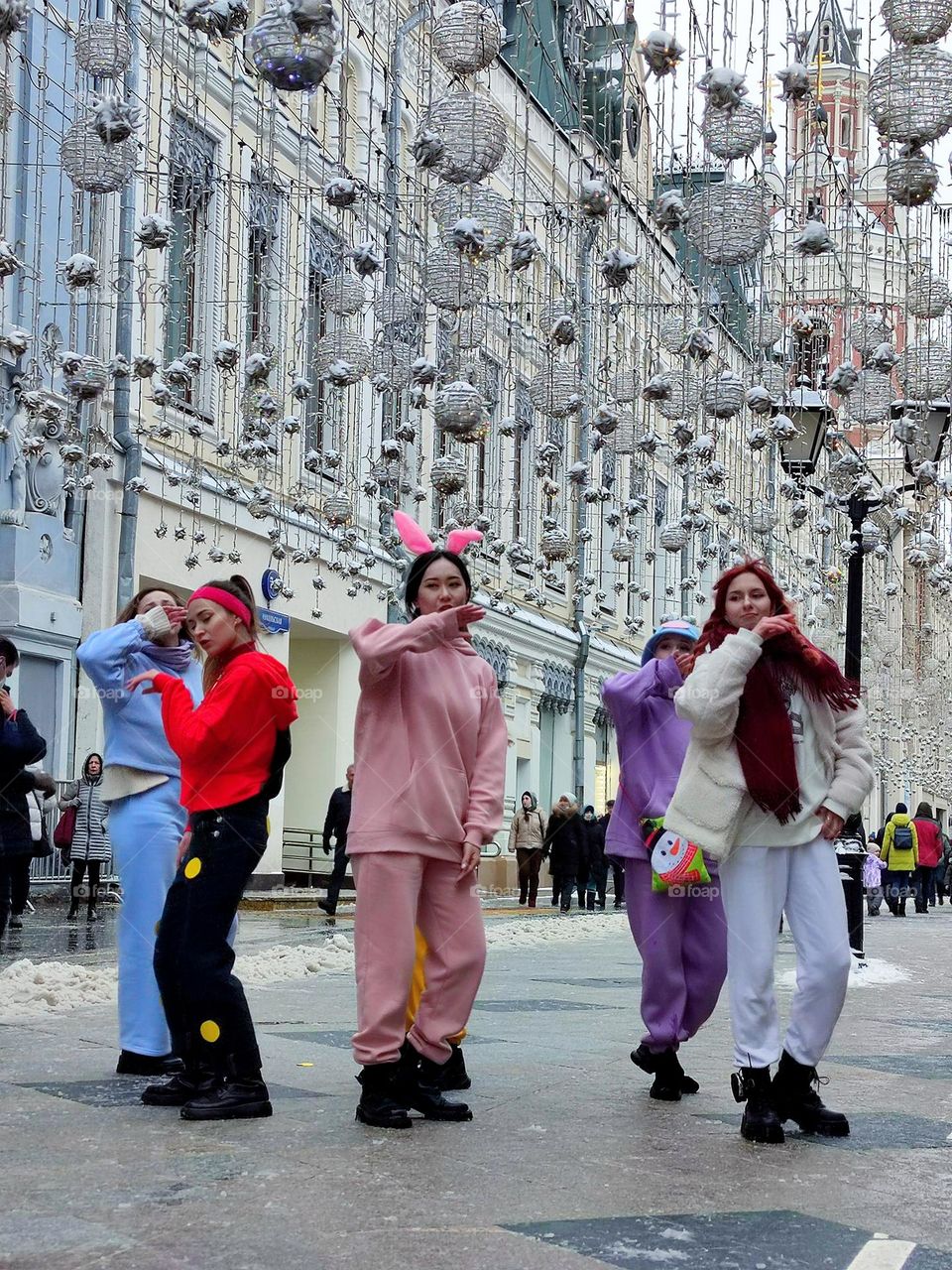 Life in motion.  A group of girls is dancing a dynamic dance on the snowy square.  Dance movements