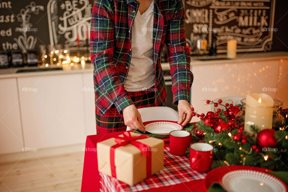 man sets a beautiful decorated winter table for a festive dinner.  Merry Christmas and Happy New Year.