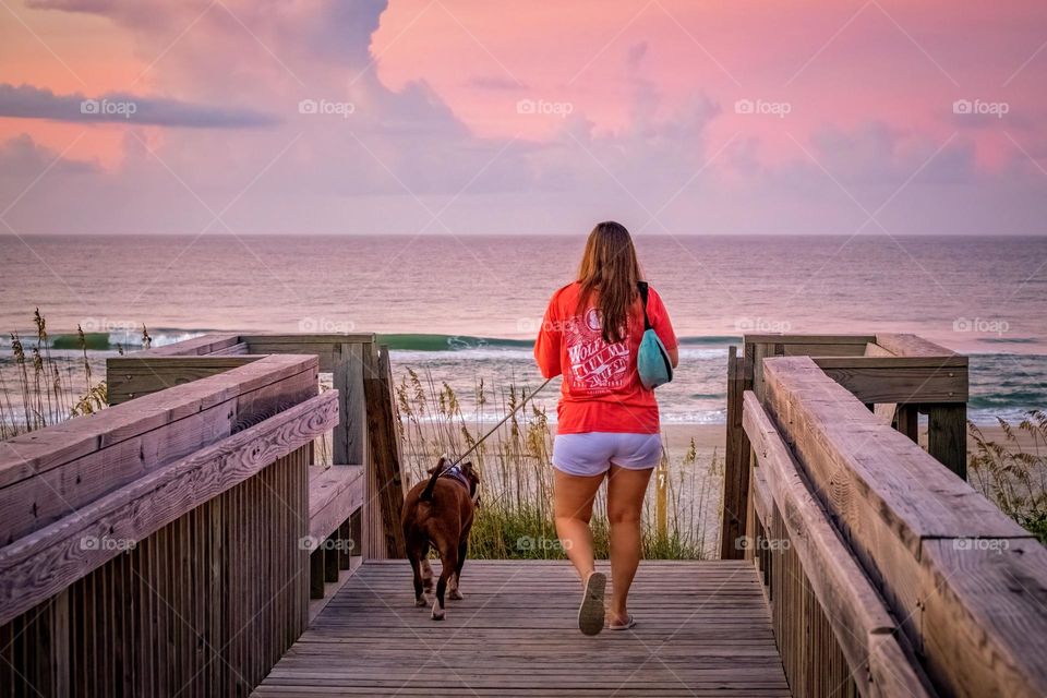 Best friends enjoy an early morning walk on the beach. Emerald Isle, North Carolina. 