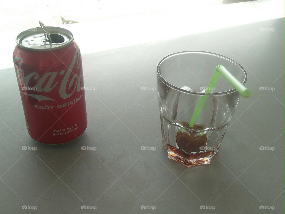 Cocacola and empty cup on table