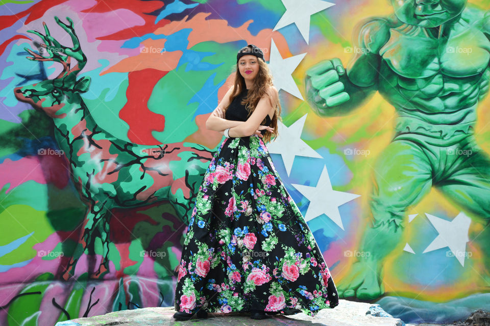 Teenage girl posing in front of painted wall