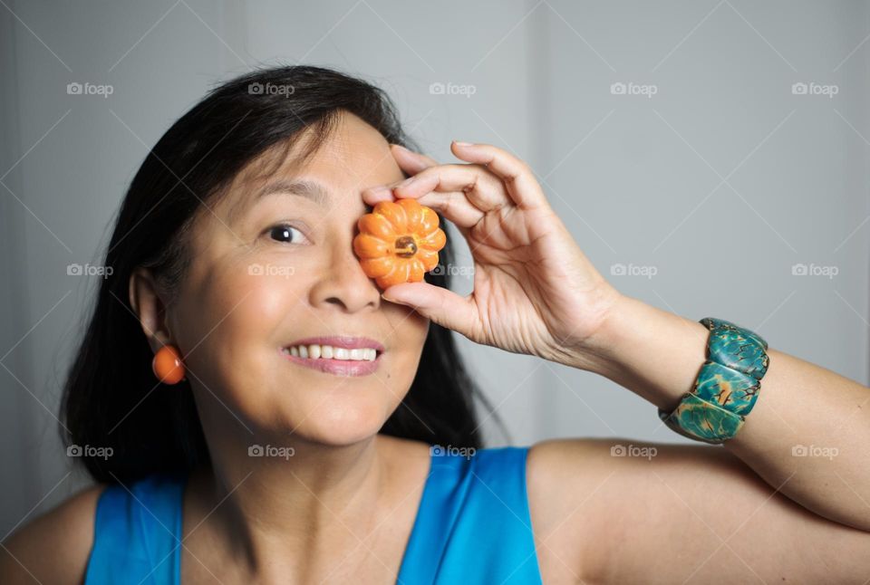 Portrait of a woman holding a pumpkin candle 