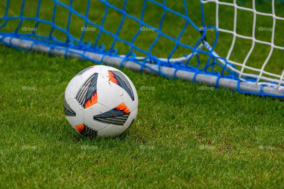 Close-up of soccer ball on grass in goal