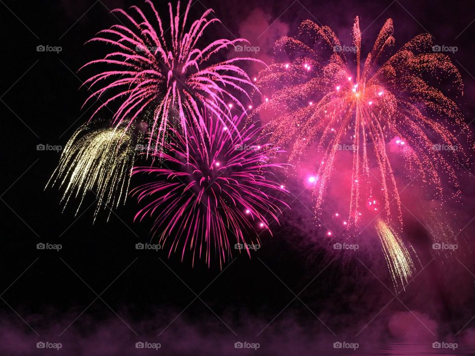 Exploding pink and gold fireworks.