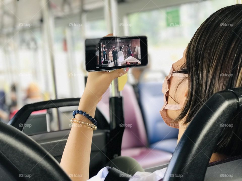 Watching movie in phone while going in bus